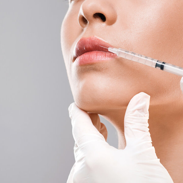 Closeup of nurse making lip injection for unrecognizable young woman, copy space